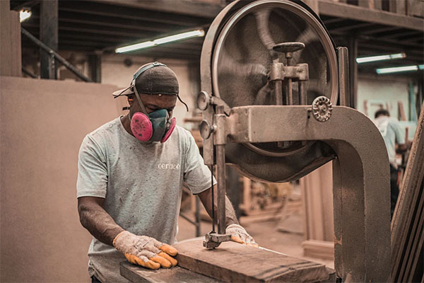 Man Working on Wooden Plank Using a Machine